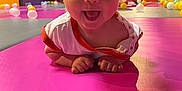 Manoë a rejoint le concours — aidez-le/la à gagner de superbes lots ! baby, child, playmat, pink, smiling, tongue_out, colorful_balls, indoor, play_area, kids, happy, person, fun, casual_clothing, head, hands, floor, background, people, recreation