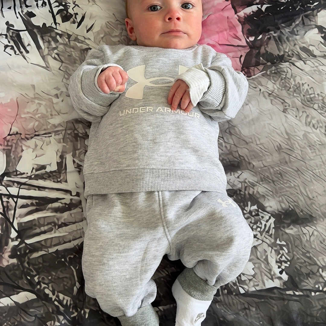 Carson is registered to the contest to win money with this photo: baby, bed, blanket, bodypart, clothing, cushion, face, finger, furniture, hand, hat, head, homedecor, knitwear, linen, newborn, pants, person, photography, portrait