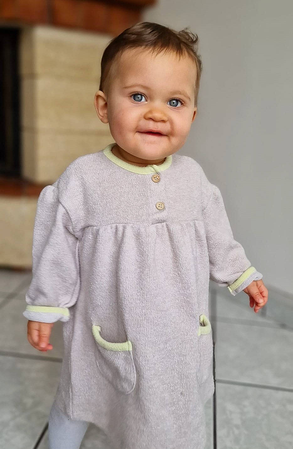 Yael participe au concours pour gagner de l'argent avec cette photo : baby, baby_toddler_clothing, cheek, child, collar, face, fashion_design, gesture, grey, happy, head, joy, neck, one_piece_garment, pattern, person, room, shoulder, sleeve, smile