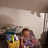 Chole is registered to the contest to win money with this photo: blanket, child, couch, cute, dress, easter_basket, floor, gift_basket, happy, home, indoor, person, plush_toy, purple_dress, shadow, sitting, smiling, toddler, toys, wall
