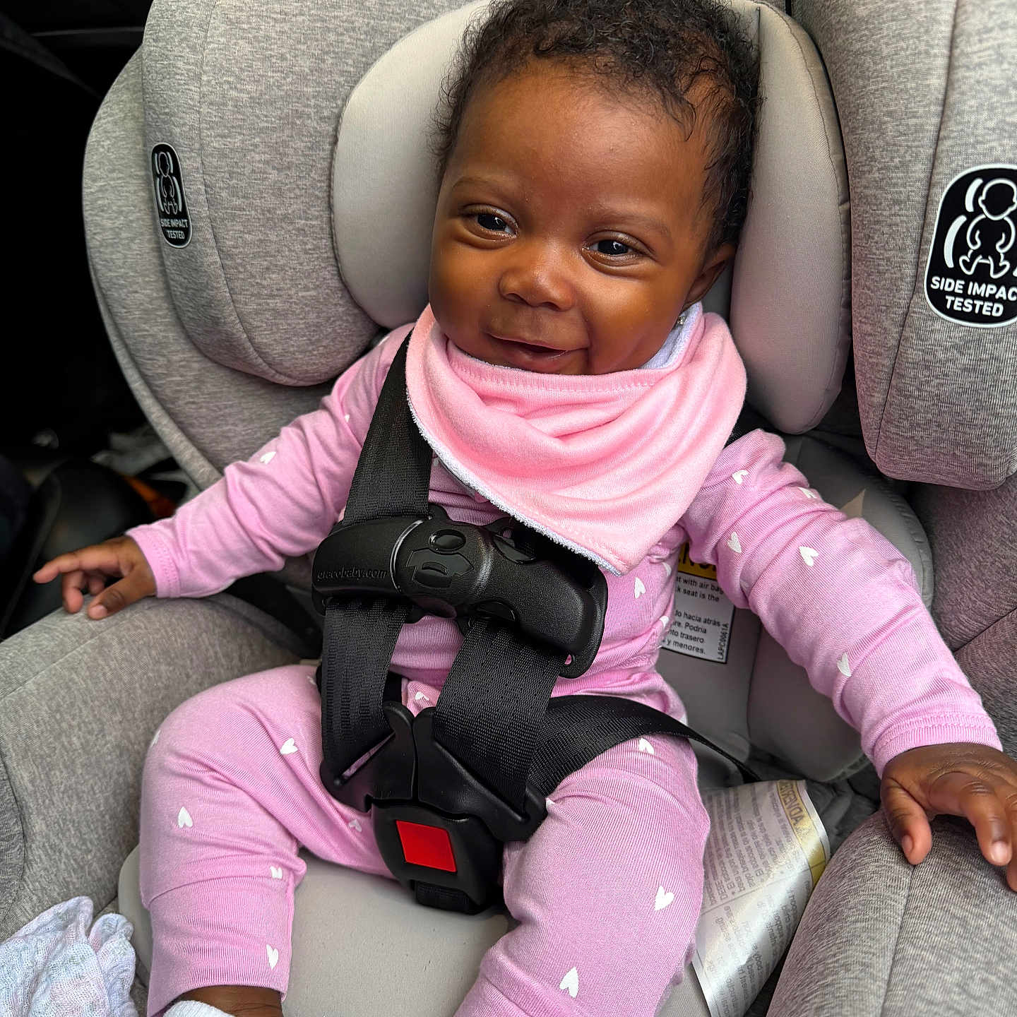 Emori joined the competition — help win amazing prizes! baby, child, car_seat, graco, pink_clothing, smiling, infant, seatbelt, safety_harness, cute, portrait, indoor, happy, head_support, footwear, baby_bib, car_interior, black_hair, skin, person