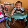 baby, child, clothing, cute, floor, furniture, happy, home, indoor, infant, person, play_kitchen, playtime, room, smiling, standing, toy, walker, wooden_floor, young_child