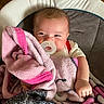 baby, pacifier, blanket, pink, gray, baby_seat, infant, cute, smile, face, clothing, indoor, child, cozy, soft, hand, head, person, comfort, warm