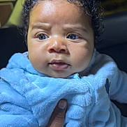 Jamari is registered to the contest to win money with this photo: baby, blue_jacket, curly_hair, hand, indoor, infant, person, portrait, skin, face, expression, young_child, clothing, cute, child, closeup, warm, holding, soft_texture, puzzled