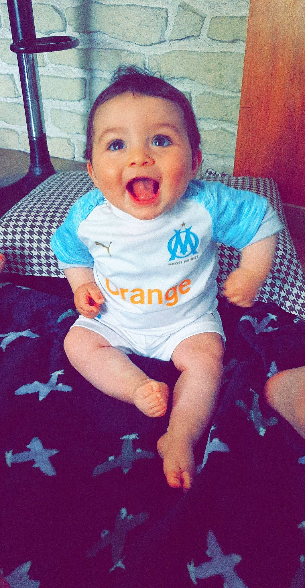 Angelino a rejoint le concours — aidez-le/la à gagner de superbes lots ! baby, baby_products, baby_toddler_clothing, cheek, child, cool, face, facial_expression, fun, head, nose, person, play, product, sitting, skin, smile, t_shirt, toddler