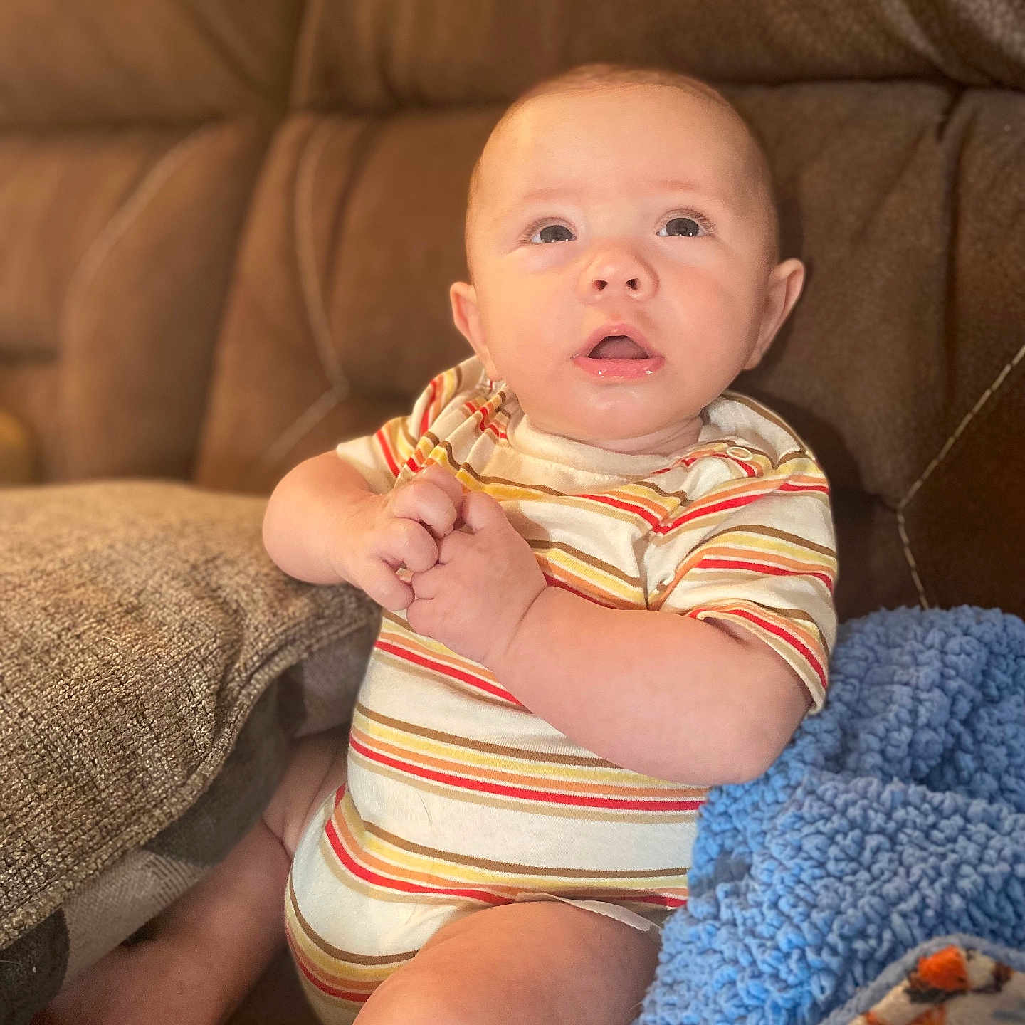 Ryker is registered to the contest to win money with this photo: baby, blanket, blonde, clothing, couch, cushion, face, furniture, hair, head, homedecor, newborn, person, photography, portrait, quilt, shorts, sitting, sleeve, t_shirt