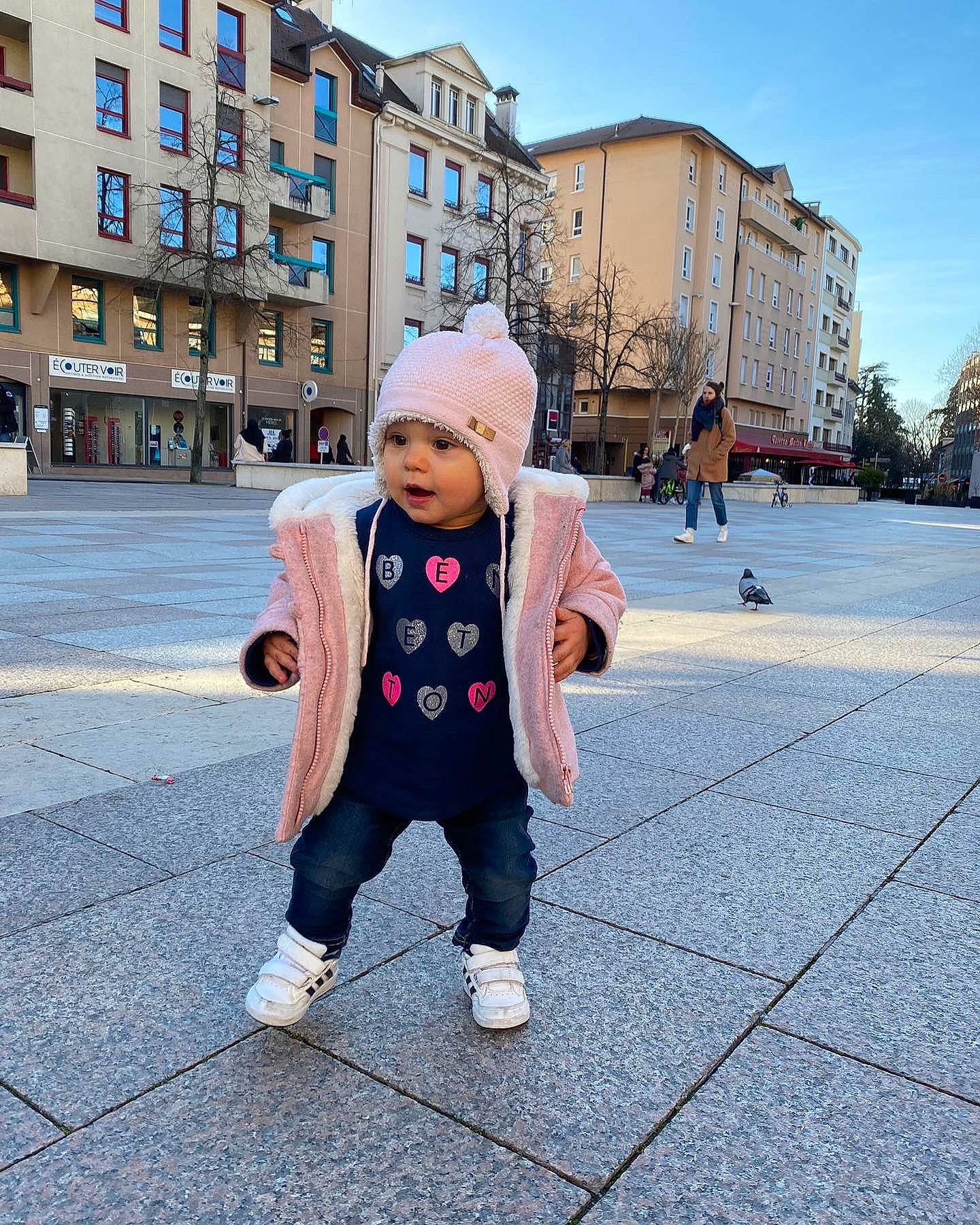 Maela participe au concours pour gagner de l'argent avec cette photo : asphalt, building, child, city, flooring, fun, happy, hat, headwear, leisure, pedestrian, person, road, road_surface, sidewalk, sky, street_fashion, toddler, travel, tree