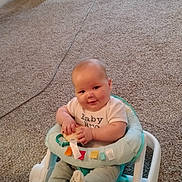 Waylin Seaton joined the competition — help win amazing prizes! baby, child, infant, smiling, sitting, activity_seat, baby_walker, carpet, indoor, living_room, office_chair, charging_cable, toy, rainbow, winnie_the_pooh, clothing, portrait, happy, home, photograph