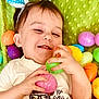 Dominic joined the competition — help win amazing prizes! toddler, child, easter_eggs, colorful, playful, smile, green_blanket, toy, hand, face, happy, indoors, cute, clothing, bow, baby, plastic_eggs, lying_down, festive, fun