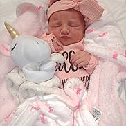 Elyanna is registered to the contest to win money with this photo: baby, newborn, infant, pink_clothing, headband, plush_toy, unicorn, blanket, pink_blanket, flamingo_pattern, sleeping, cute, soft_texture, cozy, child, portrait, indoors, resting, peaceful, wrapped