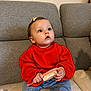 baby, child, red_sweater, hairbrush, couch, gray_couch, curious, indoor, sitting, blue_jeans, white_socks, bow, cute, infant, portrait, furniture, casual, hands, expression, young_child