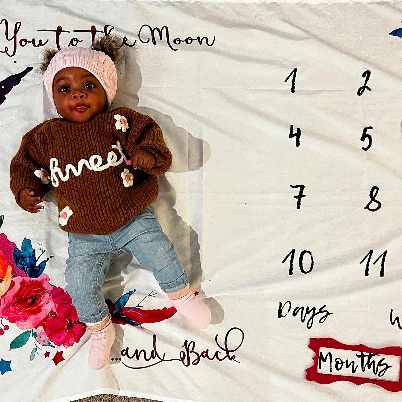 Halo is registered to the contest to win money with this photo: baby, cap, clothing, face, flower, hat, head, hood, hosiery, knitwear, number, pants, person, photography, portrait, sitting, sock, sweater, symbol, text