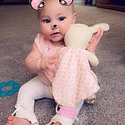 Destiny joined the competition — help win amazing prizes! baby, child, toy, carpet, stuffed_animal, pink_clothing, home_interior, furniture, drawer, window_blinds, playful_filter, face_filter, cute, sitting, barefoot, infant, indoor, colorful, soft_toy, smiling