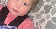 Destiny joined the competition — help win amazing prizes! toddler, child, blanket, pink_clothing, face, hand, blue_eyes, pony_tail, cushion, patterned_background, indoor, baby, person, portrait, cozy, soft_texture, cute, snuggled, casual, young_child