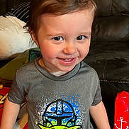 Levi is registered to the contest to win money with this photo: child, toddler, smiling, indoors, tshirt, baby_yoda, mandalorian, couch, cushion, toy, happy, face, short_sleeves, camouflage_pants, hair, person, clothing, living_room, cute, playful