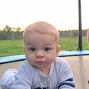 Nathan participe au concours pour gagner de l'argent avec cette photo : baby, child, crawling, trampoline, outdoor, grass, field, sky, young_child, infant, curious, casual_clothing, long_sleeve, daylight, nature, playtime, portrait, face, hand, person