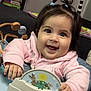 Nevaeh is registered to the contest to win money with this photo: baby, child, smiling, indoor, walker, toy, pigtails, pink_jacket, happy, face, person, cute, infant, play, furniture, living_room, board_games, fish_tank, hand, seat