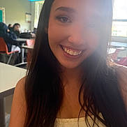 Layla joined the competition — help win amazing prizes! girl, smile, portrait, classroom, student, long_hair, indoors, young_person, face, casual_clothing, table, chair, window, natural_light, people, background, happy, education, desk, blurry_background