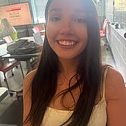 Kayla is registered to the contest to win money with this photo: teenage_girl, smile, long_hair, classroom, desk, chair, computer_screen, window, backpack, casual_clothing, indoor, education, student, happy, portrait, young_person, school, female, learning, daylight