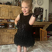 Lya participe au concours pour gagner de l'argent avec cette photo : black_dress, cabinet, child, clock, curtain, decor, dress, fireplace, furniture, girl, gloves, happy, home, indoor, kitchen, pose, shoe, smile, socks, table