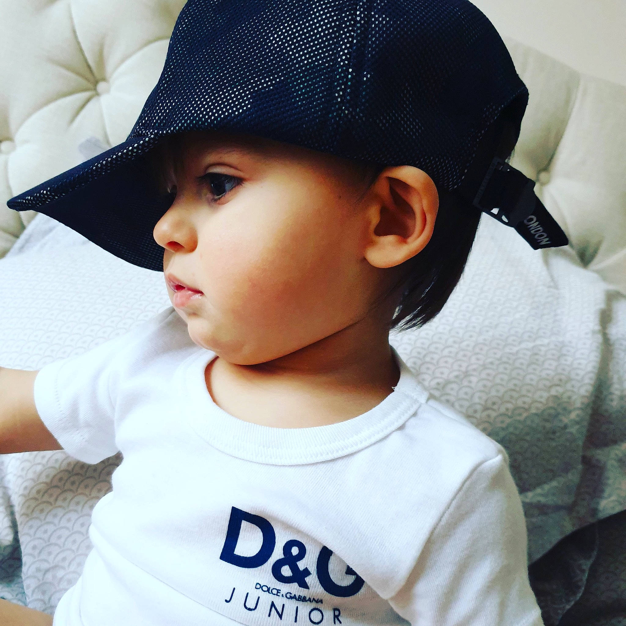 Matteo is registered to the contest to win money with this photo: baby, baseball_cap, beanie, black_hair, cap, cheek, child, chin, clothing, cool, ear, fashion_accessory, hat, headgear, headwear, lip, neck, person, sun_hat, t_shirt