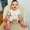 baby, nine_months, infant, child, smiling, blue_eyes, striped_overalls, dog_prints, wooden_sign, chair, indoor, carpeted_stairs, baby_gate, wooden_floor, cute, plush_chair, person, sitting, happy, portrait