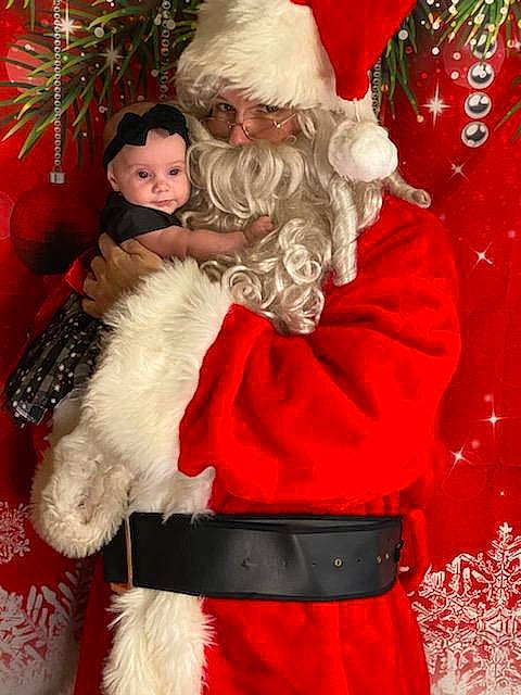 Michele is registered to the contest to win money with this photo: christmas, christmas_decoration, christmas_eve, christmas_ornament, costume_accessory, costume_hat, event, facial_hair, fictional_character, fur, fur_clothing, headwear, holiday, holiday_ornament, human, human_body, interior_design, person, red, santa_claus