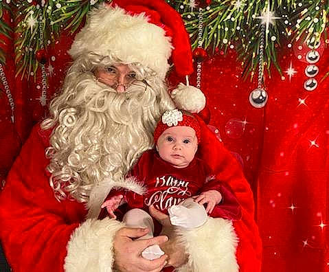 Michele is registered to the contest to win money with this photo: baby_toddler_clothing, beard, christmas, christmas_decoration, christmas_eve, christmas_ornament, costume_accessory, event, facial_hair, fictional_character, fur, fur_clothing, happy, headwear, holiday, human, human_body, nose, person, red