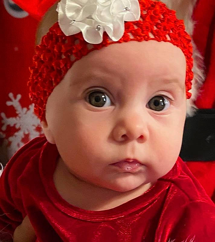 Michele is registered to the contest to win money with this photo: baby, baby_toddler_clothing, bonnet, cheek, child, chin, coquelicot, costume_accessory, forehead, hair_accessory, headgear, headpiece, headwear, iris, lip, mouth, nose, person, red, skin