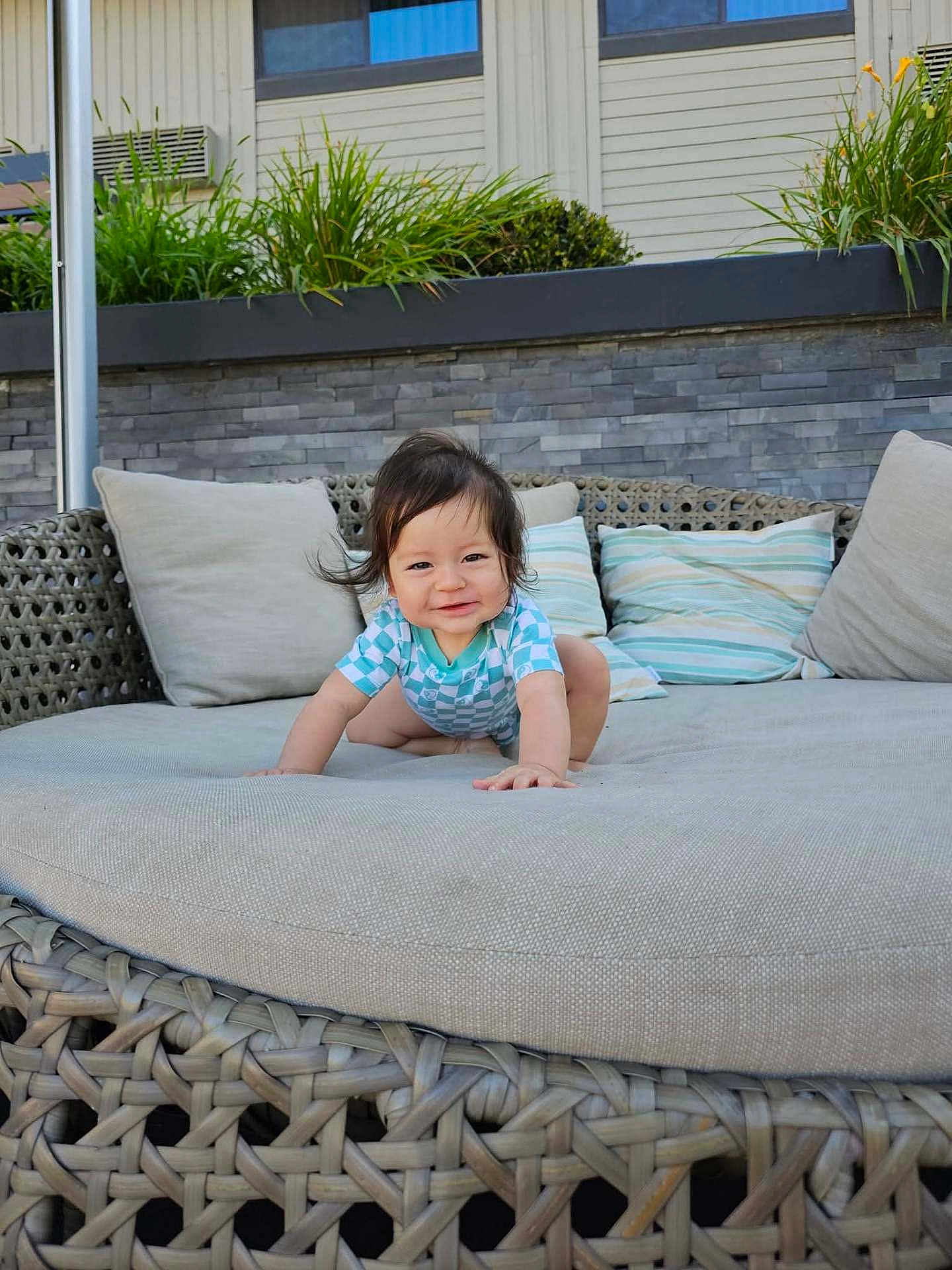 Ethan joined the competition — help win amazing prizes! baby, child, smiling, crawling, outdoor, sofa, cushion, wicker, pillow, greenery, plant, home, furniture, portrait, happy, person, clothing, daylight, cute, infant