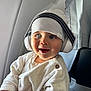 Ange participe au concours pour gagner de l'argent avec cette photo : baby, child, headphones, hat, beanie, blue_eyes, sweater, airplane, window, seat, cute, smiling, portrait, indoor, travel, infant, clothing, hands, seatback, happy