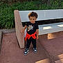 Preston joined the competition — help win amazing prizes! toddler, child, curly_hair, black_shirt, nike, red_jacket, sneakers, outdoor, bench, sidewalk, greenery, tree, casual_clothing, young_child, standing, person, daylight, concrete, park, fashion
