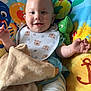 baby, smiling, bib, blanket, play_mat, toy, turtle, sea_creatures, colorful, infant, cute, happy, child, indoor, soft_toy, clothing, sock, face, person, portrait