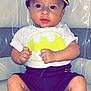 Ménélas a rejoint le concours — aidez-le/la à gagner de superbes lots ! baby, infant, batman, cap, shirt, shorts, fists, couch, leather, plastic_cover, sitting, cute, child, portrait, indoor, clothing, foot, expression, face, person