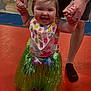 Nora joined the competition — help win amazing prizes! toddler, child, adult, holding_hands, grass_skirt, floral_top, smiling, indoor, play_area, barefoot, colorful, happy, person, floor_mat, tattoo, sock, learning_to_walk, fun, celebration, family