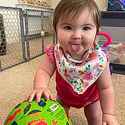 Nora joined the competition — help win amazing prizes! baby, child, tongue_out, indoor, ball, colorful, play_area, carpet, bib, animal_print, safety_gate, toy, cute, smiling, person, infant, floor, clothing, fun, happy