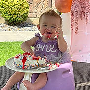 Ayrora joined the competition — help win amazing prizes! baby, birthday_cake, purple_dress, smiling, face, hand, frosting, sprinkles, outdoor, grass, balloons, decorations, seat, foot, table, celebration, one_year_old, happy, messy, child