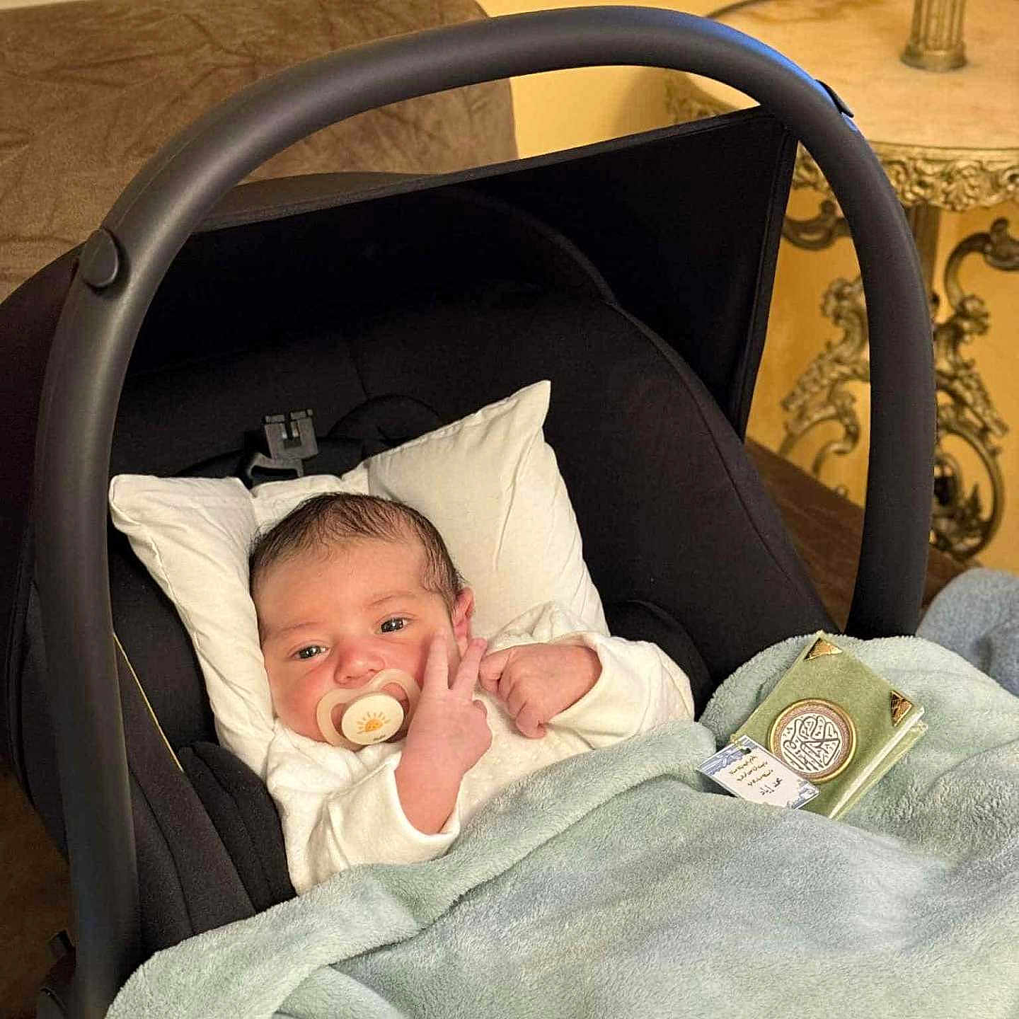 Mohmed Iyed participe au concours pour gagner de l'argent avec cette photo : baby, baby_carrier, blanket, clothing, comfort, couch, cute, face, furniture, hand, indoor, infant, newborn, pacifier, person, pillow, resting, soft, table, warm