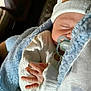 baby, sleeping, pacifier, blanket, hat, hand, cozy, infant, clothing, closeup, soft_light, cute, peaceful, resting, wrapped, newborn, warm, texture, portrait, indoors