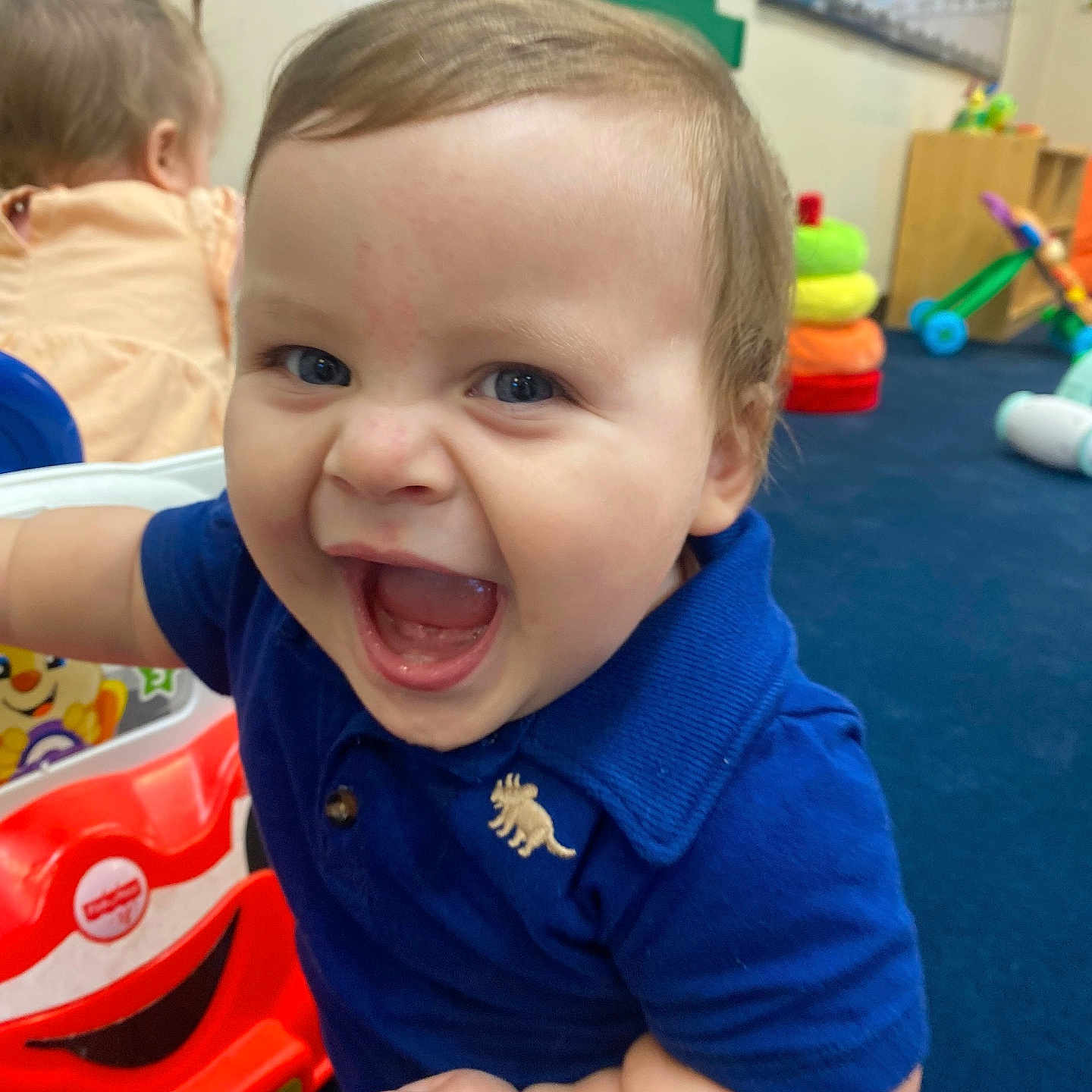 Amilio is registered to the contest to win money with this photo: accessories, baby, babylaughing, bodypart, clothing, face, happy, head, indoors, laughing, mouth, person, photoframe, photography, playarea, portrait, smile, t_shirt, teeth, toy