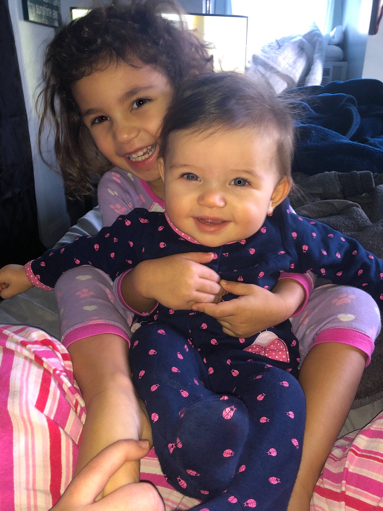 Ari is registered to the contest to win money with this photo: baby_toddler_clothing, cheek, child, face, finger, fun, gesture, hairstyle, happy, head, interaction, iris, joy, lap, leg, person, pink, purple, skin, sleeve