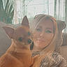 Gabbana is registered to the contest to win money with this photo: blonde_hair, casual, casual_clothing, comfortable, companion, cozy, curtains, cute_pet, dog, home, indoor, natural_light, pet, plant, portrait, relaxed, small_dog, smiling, sofa, woman