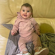 Noëlyne participe au concours pour gagner de l'argent avec cette photo : baby, child, pink_clothing, hoodie, pants, sneakers, couch, leather, blanket, happy, smiling, indoor, person, seated, cute, young, cozy, casual, comfortable, portrait