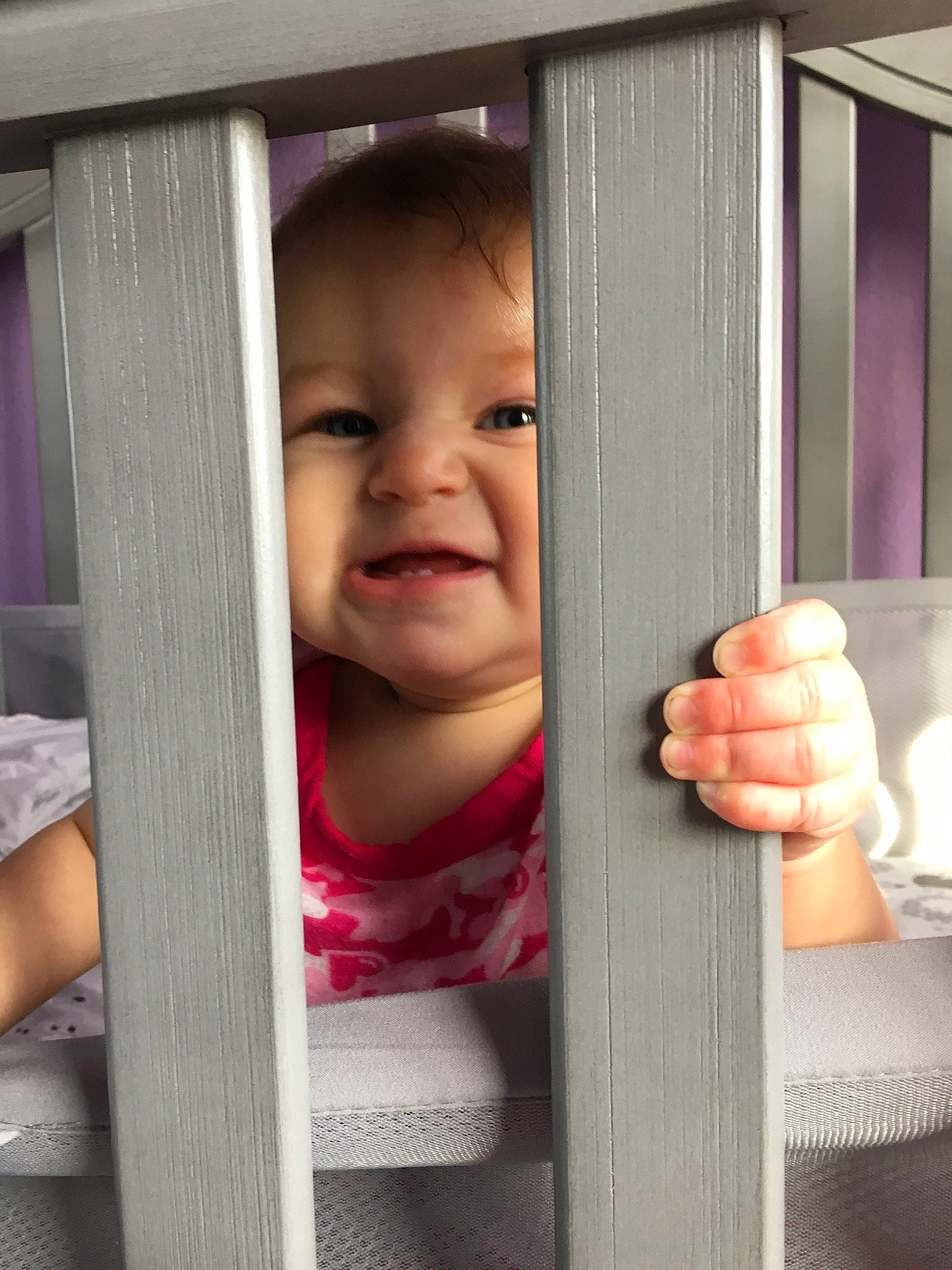 Dahlia is registered to the contest to win money with this photo: baby, child, door, face, finger, gesture, hand, person, pink, skin, smile, standing, thumb, toddler, window, wood