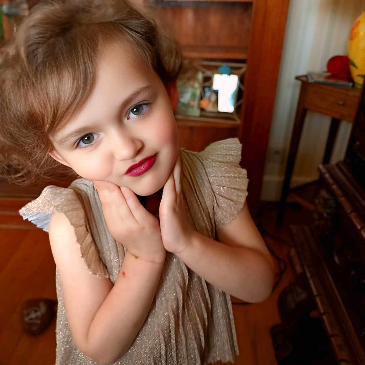 Myriana participe au concours pour gagner de l'argent avec cette photo : cabinet, child, cozy, cute, decor, dress, expression, face, furniture, hair, hands, indoor, lamp, person, portrait, posing, smile, warm_lighting, wooden_floor, young
