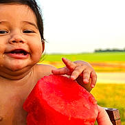 River is registered to the contest to win money with this photo: baby, child, watermelon, fruit, smiling, happy, outdoor, nature, summer, greenery, hand, skin, food, fresh, cute, portrait, closeup, grass, sunlight, joy
