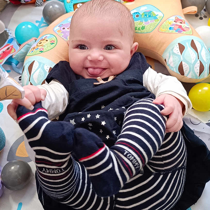 Zuleyha a rejoint le concours — aidez-le/la à gagner de superbes lots ! baby, ball, child, colorful, cute, floor, hands, happy, indoors, infant, legs, person, play_mat, playpen, smiling, soft_toy, striped_clothing, stuffed_animal, tongue_out, toy