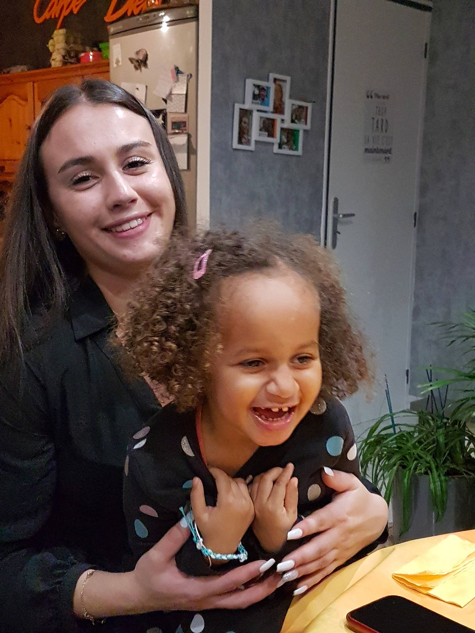 Maya participe au concours pour gagner de l'argent avec cette photo : child, event, facial_expression, flowerpot, fun, gesture, hairstyle, hand, happy, houseplant, iris, jewellery, joy, person, picture_frame, plant, sitting, skin, smile, table