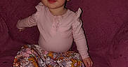 Esmae is registered to the contest to win money with this photo: baby, child, infant, sitting, portrait, smiling, face, bow, pink_clothing, floral_skirt, bare_feet, couch, sofa, indoor, home, fabric, headband, blonde_hair, happy, full_body