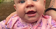 Esmae joined the competition — help win amazing prizes! adorable, adult, baby, child, close_up, eyes, face, hands, happy, head, infant, outdoors, patterned_clothing, photography, pink_outfit, portrait, sitting, smiling, support, wide_eyed